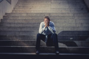 businessman crying lost in depression sitting on street concrete stairs